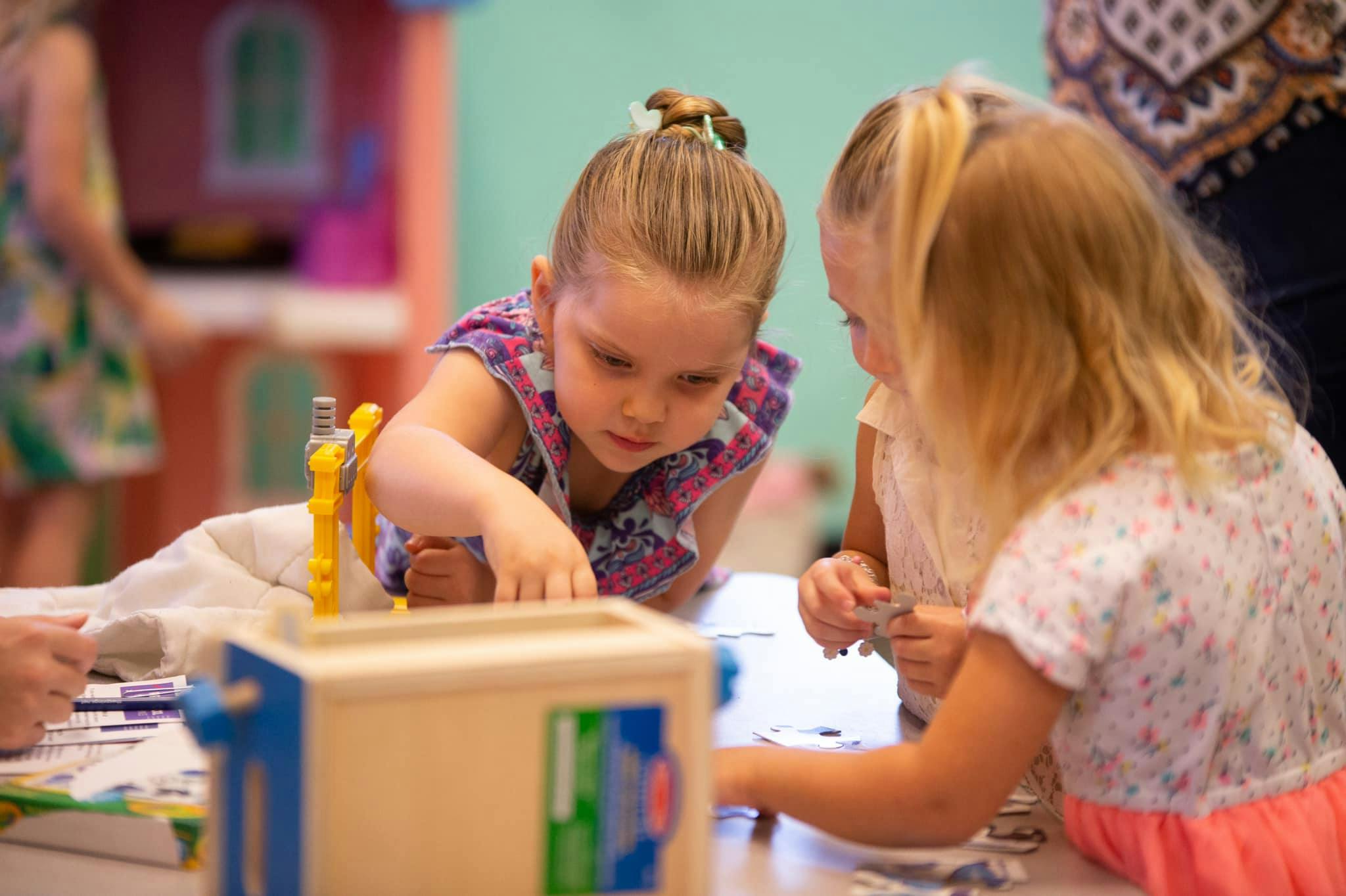 Two children playing with toys at a table