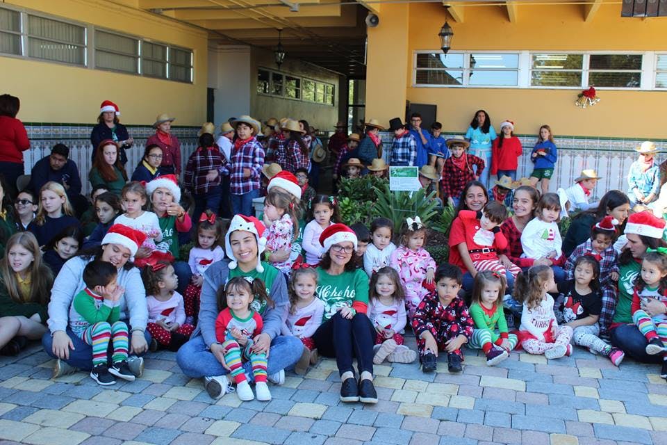 Large group of adults and children in holiday attire gathered outdoors