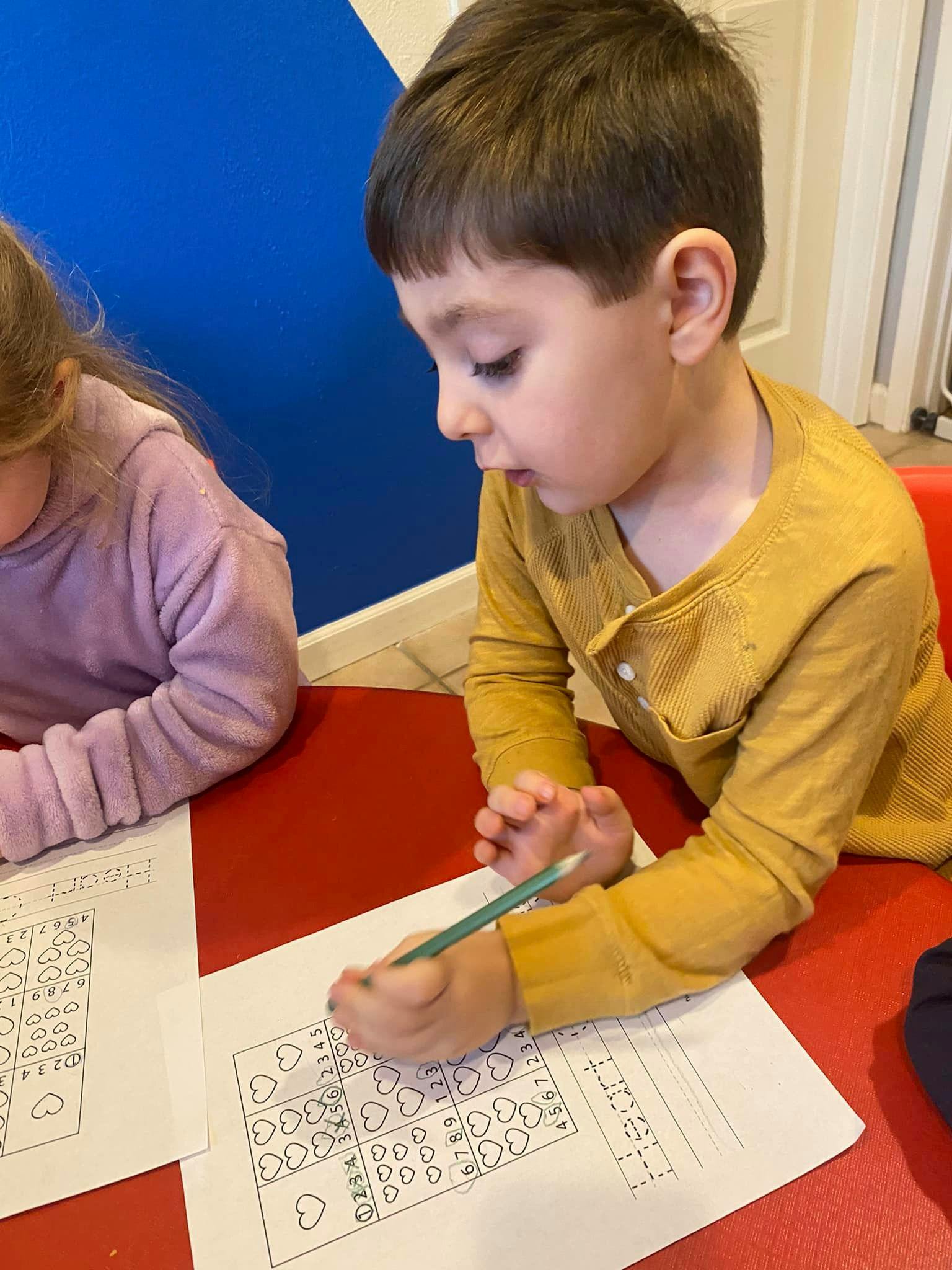 Child drawing on paper with a pencil