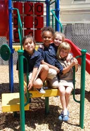 Four children sitting on playground equipment