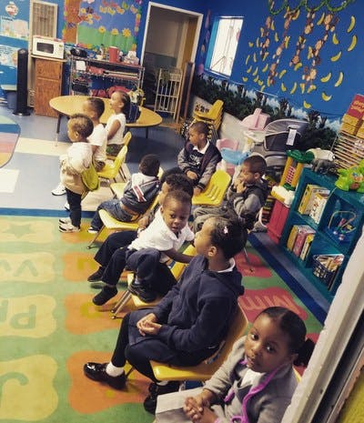 Children sitting in chairs in a classroom