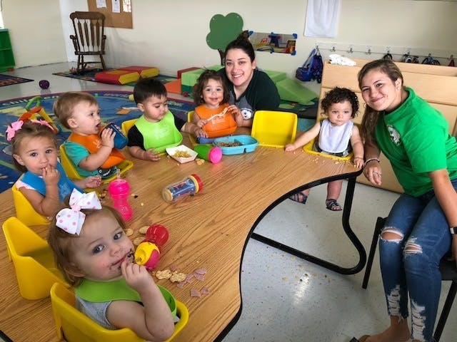 Two people with five children eating at a table
