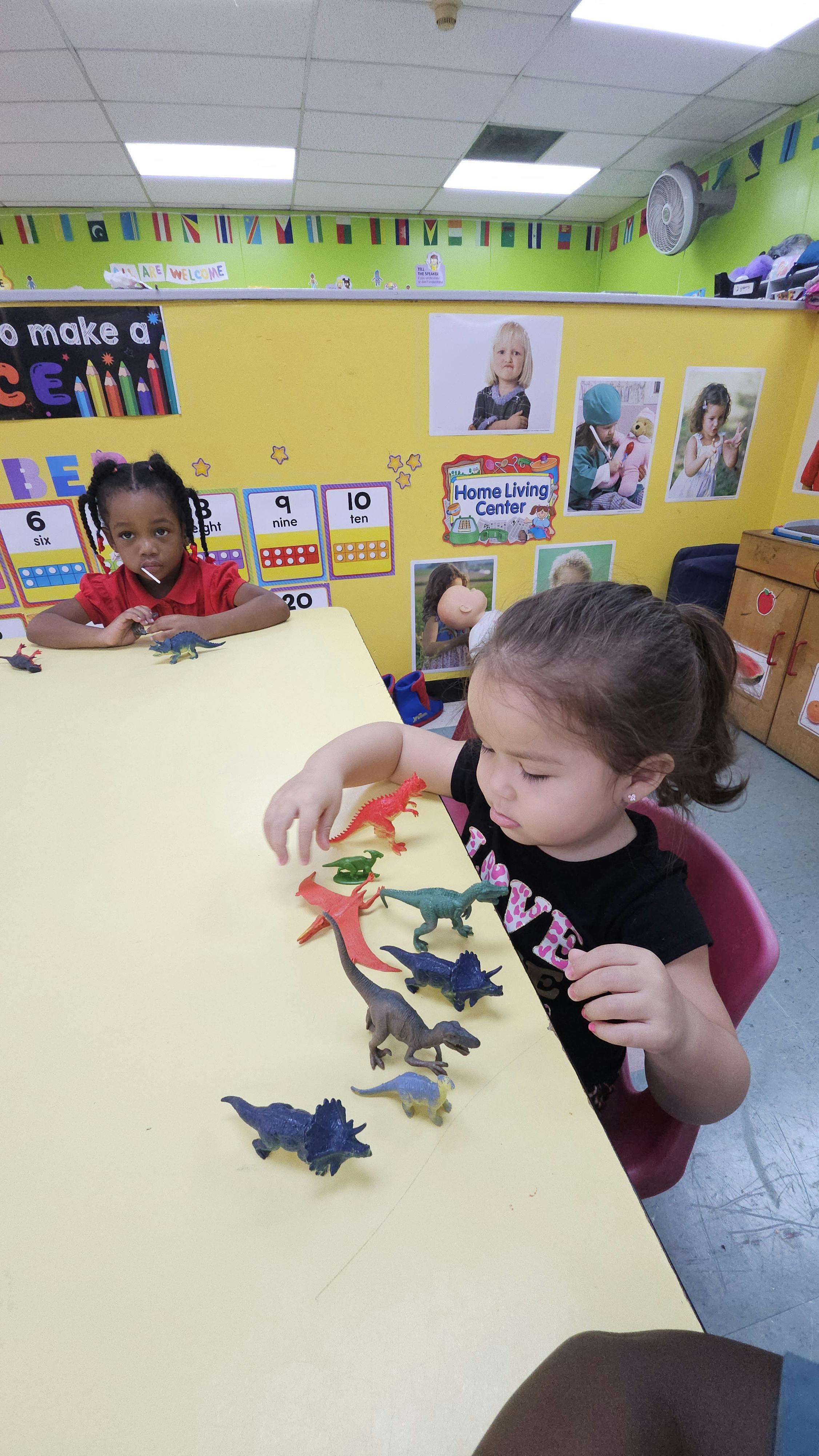 Child playing with dinosaur toys at a table