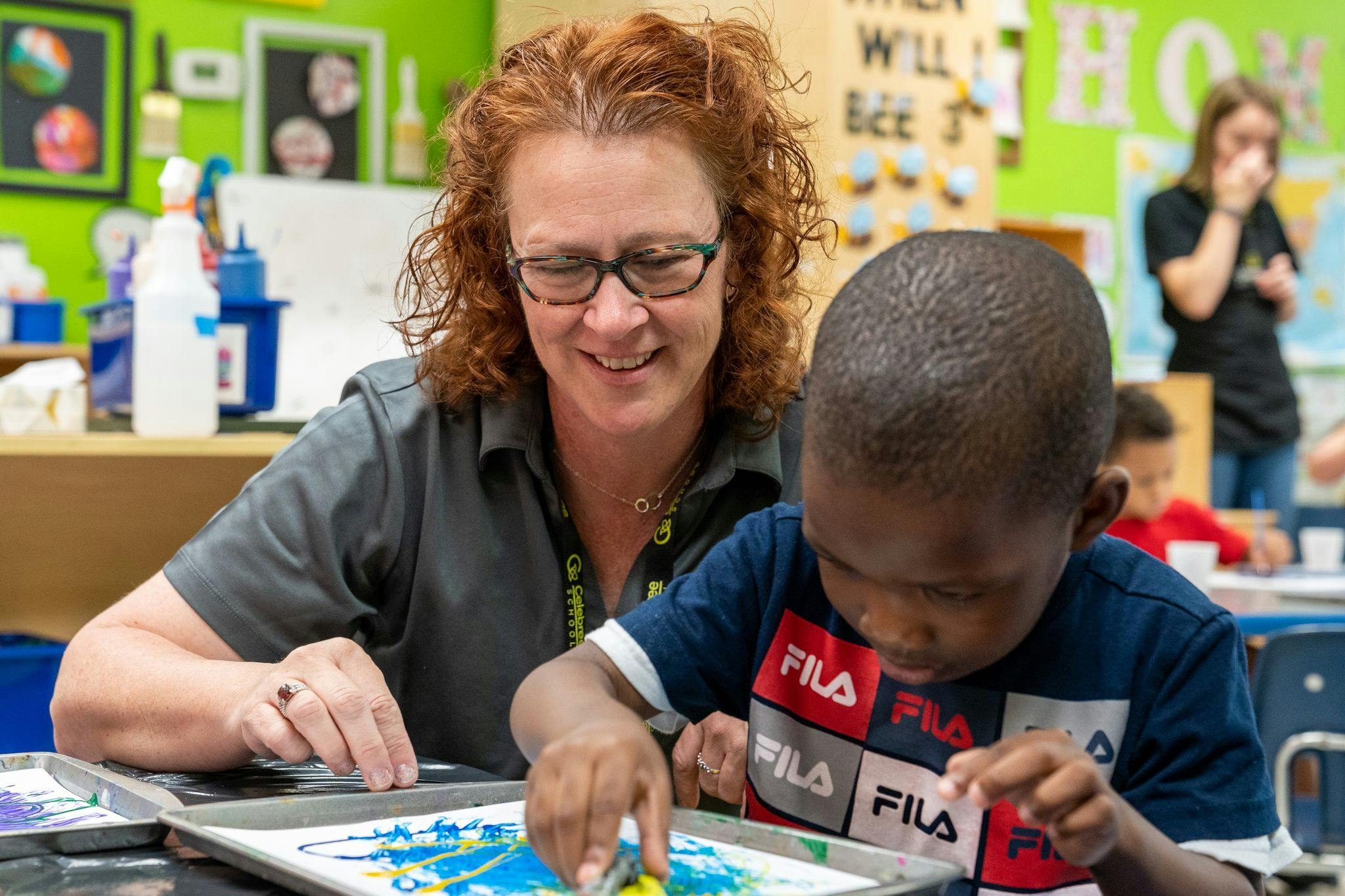 Adult and child doing an art activity in a classroom