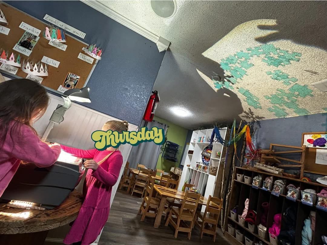 Two children interacting with an object in a classroom
