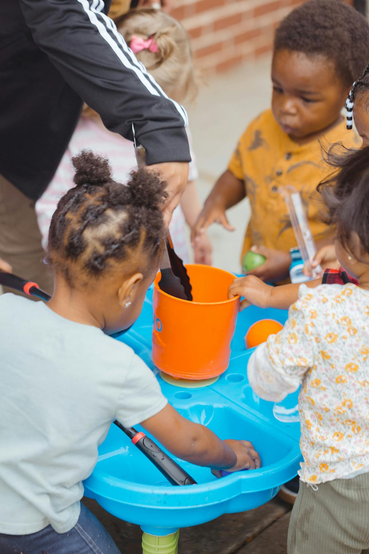 Adult and children playing with water table and toys