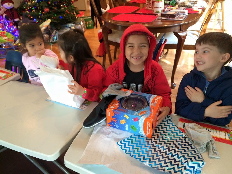 Four children opening gifts