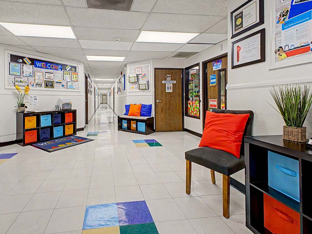 Hallway with colorful decor, a welcome mat, and seating