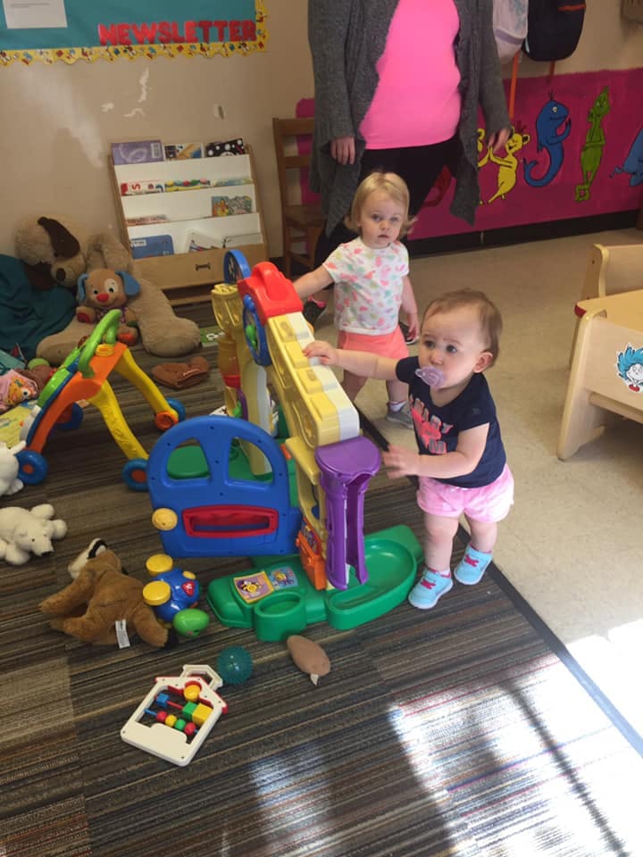 Two children playing with colorful toys in a room