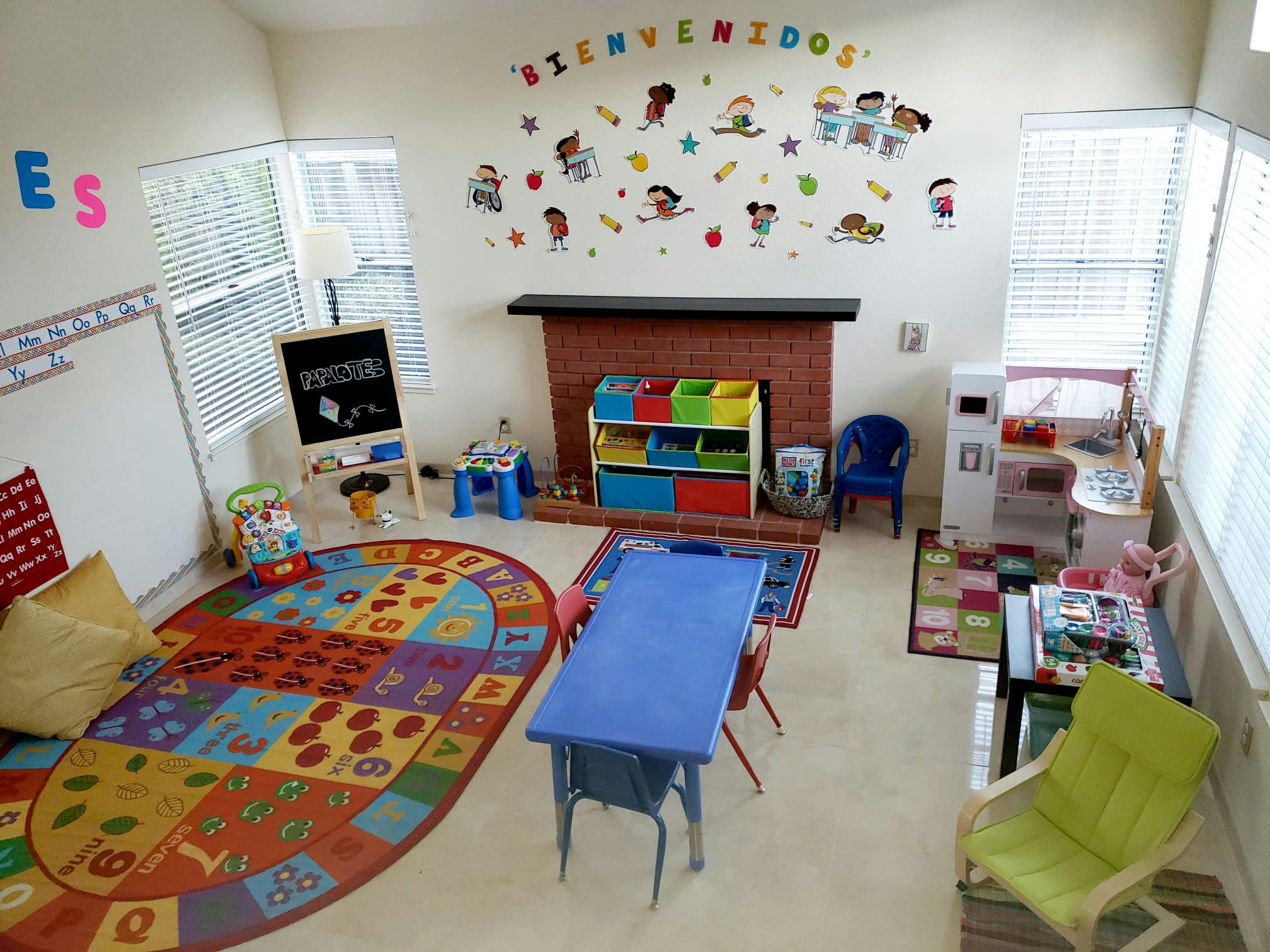 Playroom with colorful rug, small tables, and wall decorations