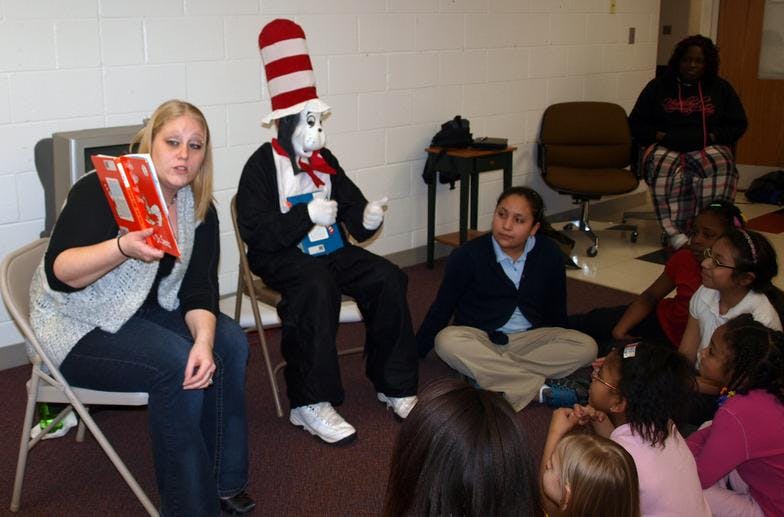 Person in Cat in the Hat costume with children and adults