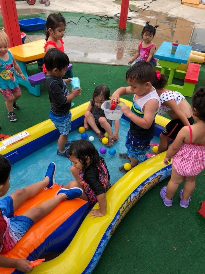 Children playing in an inflatable pool with colorful balls