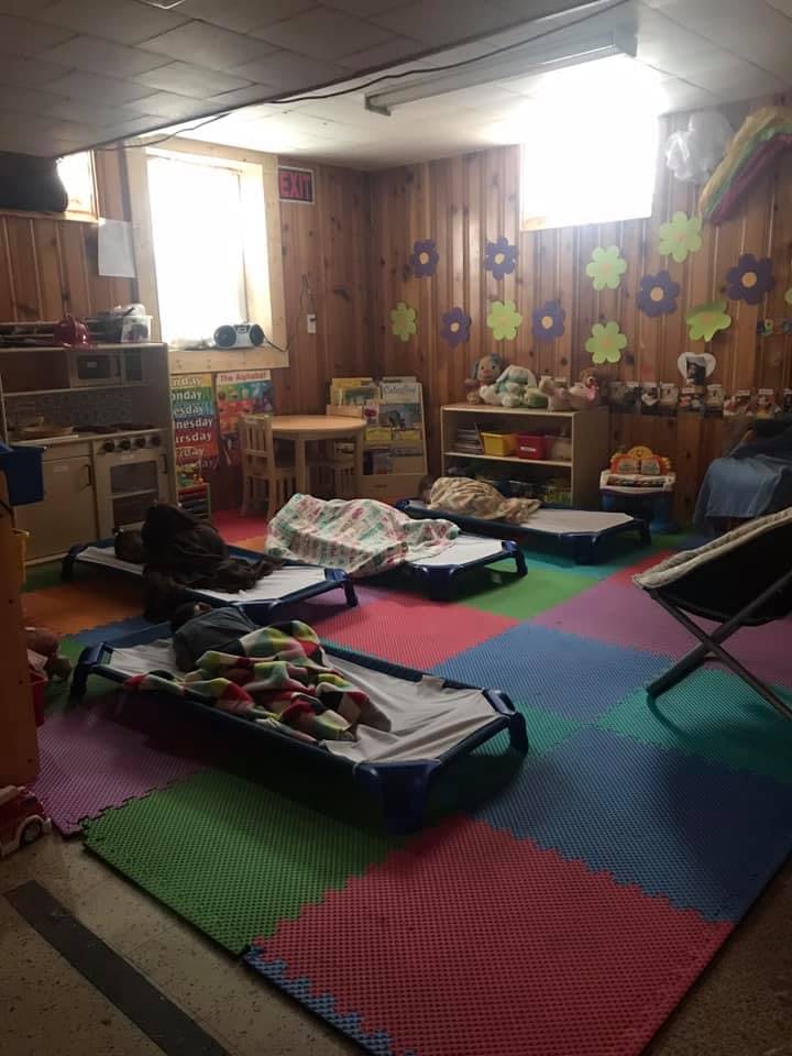 Daycare room with several cots on a colorful mat