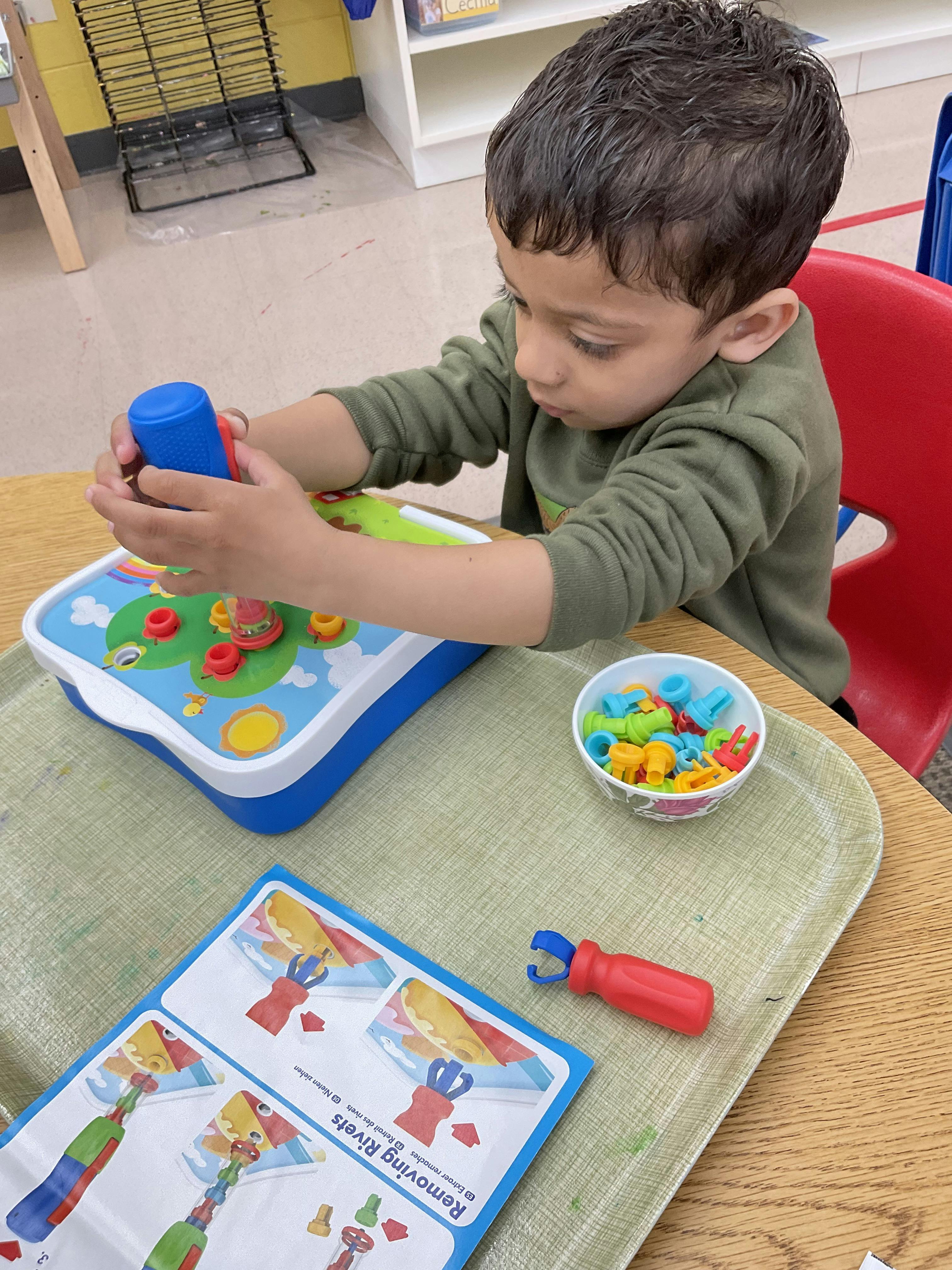 Child playing with a toy with colorful pieces