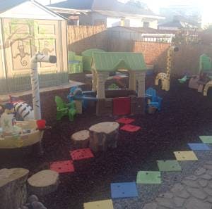 Outdoor play area with playhouse and stepping stones