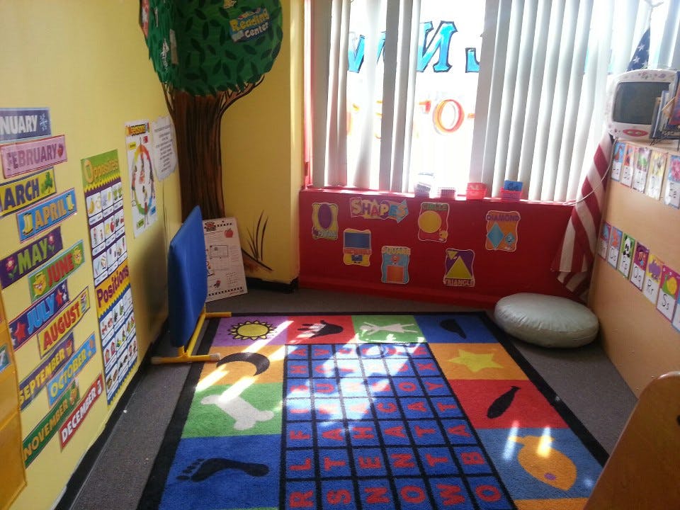 Colorful classroom with a patterned rug and educational posters