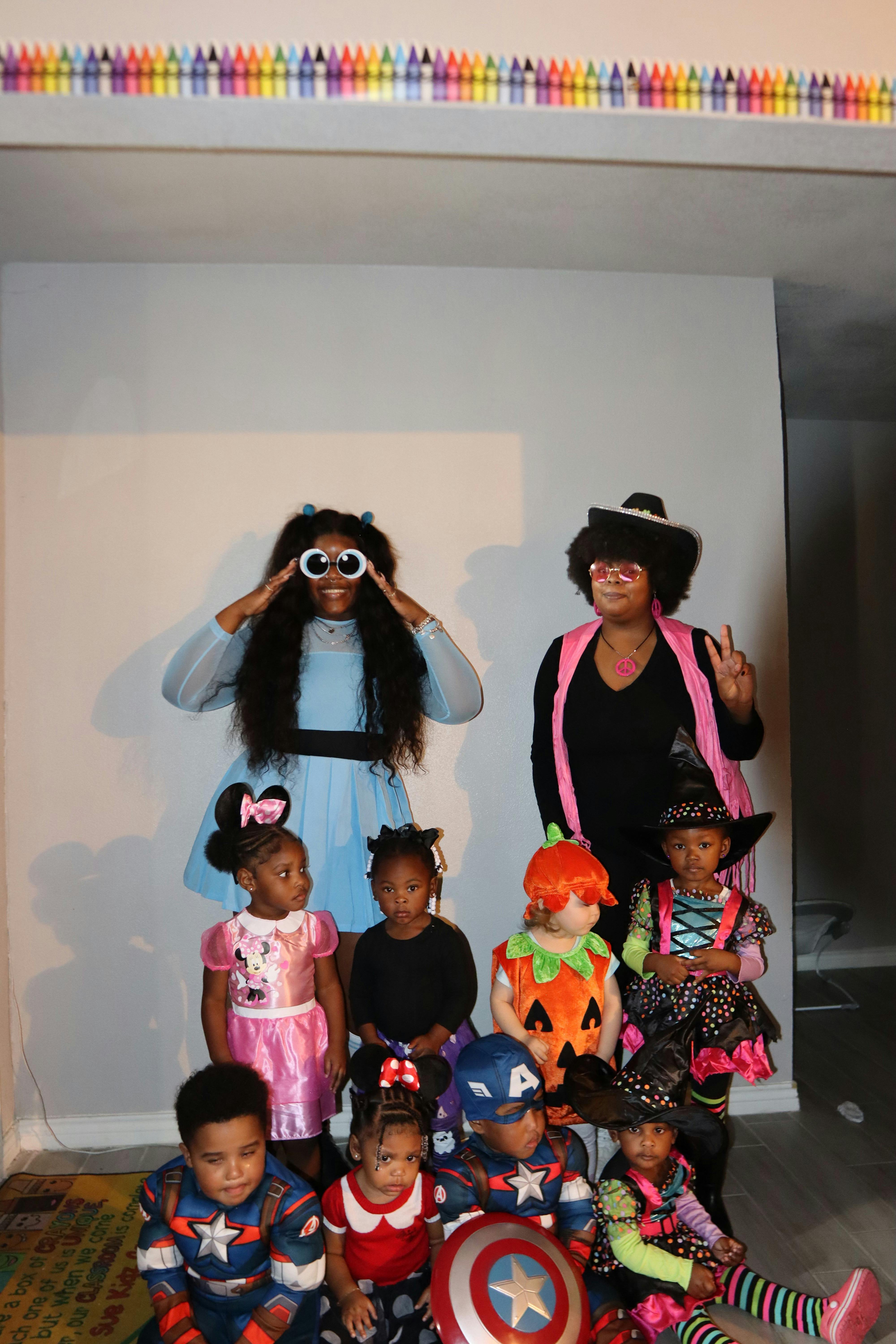 Two people and multiple children in various costumes