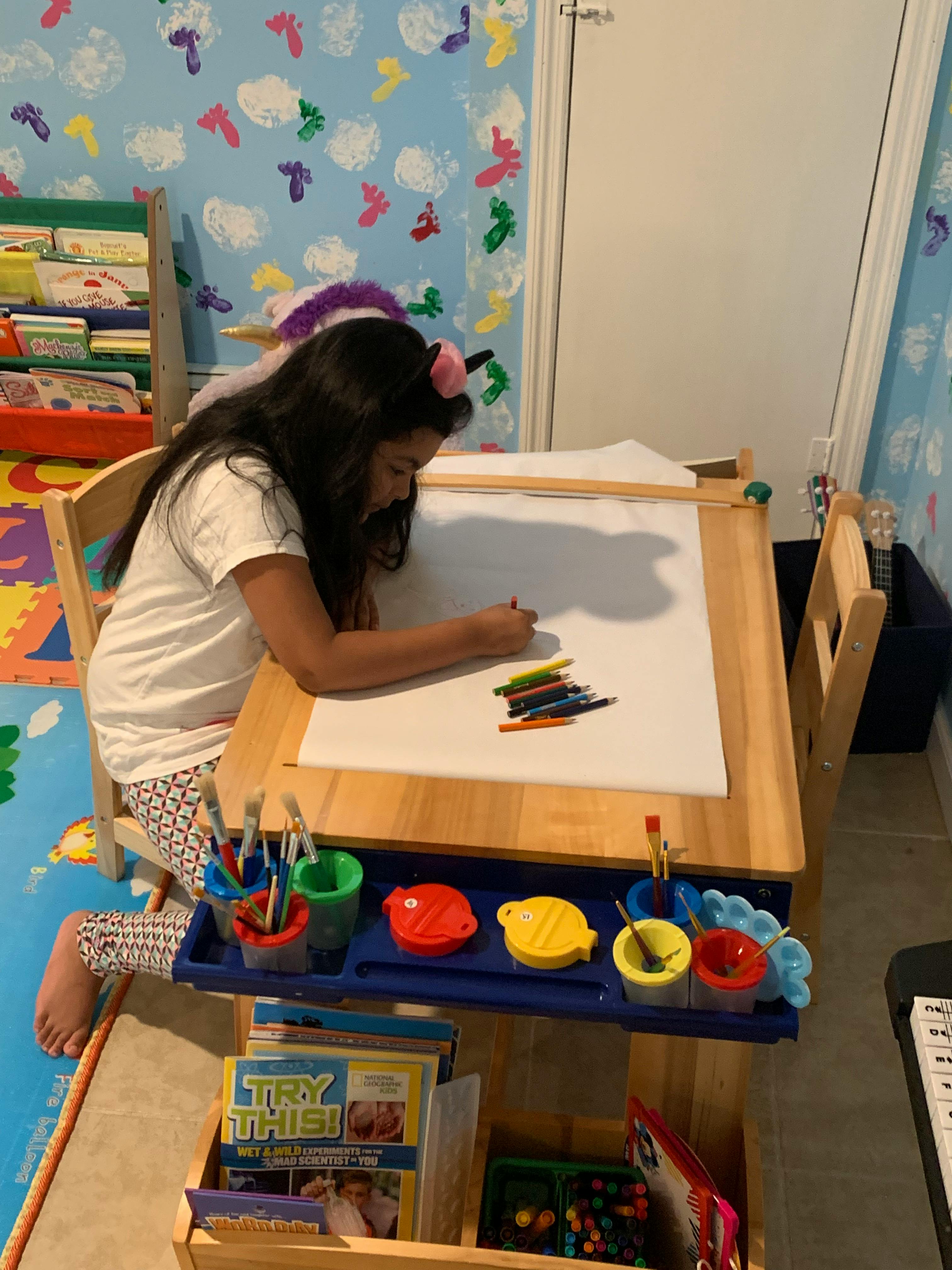 Child drawing on an easel with crayons