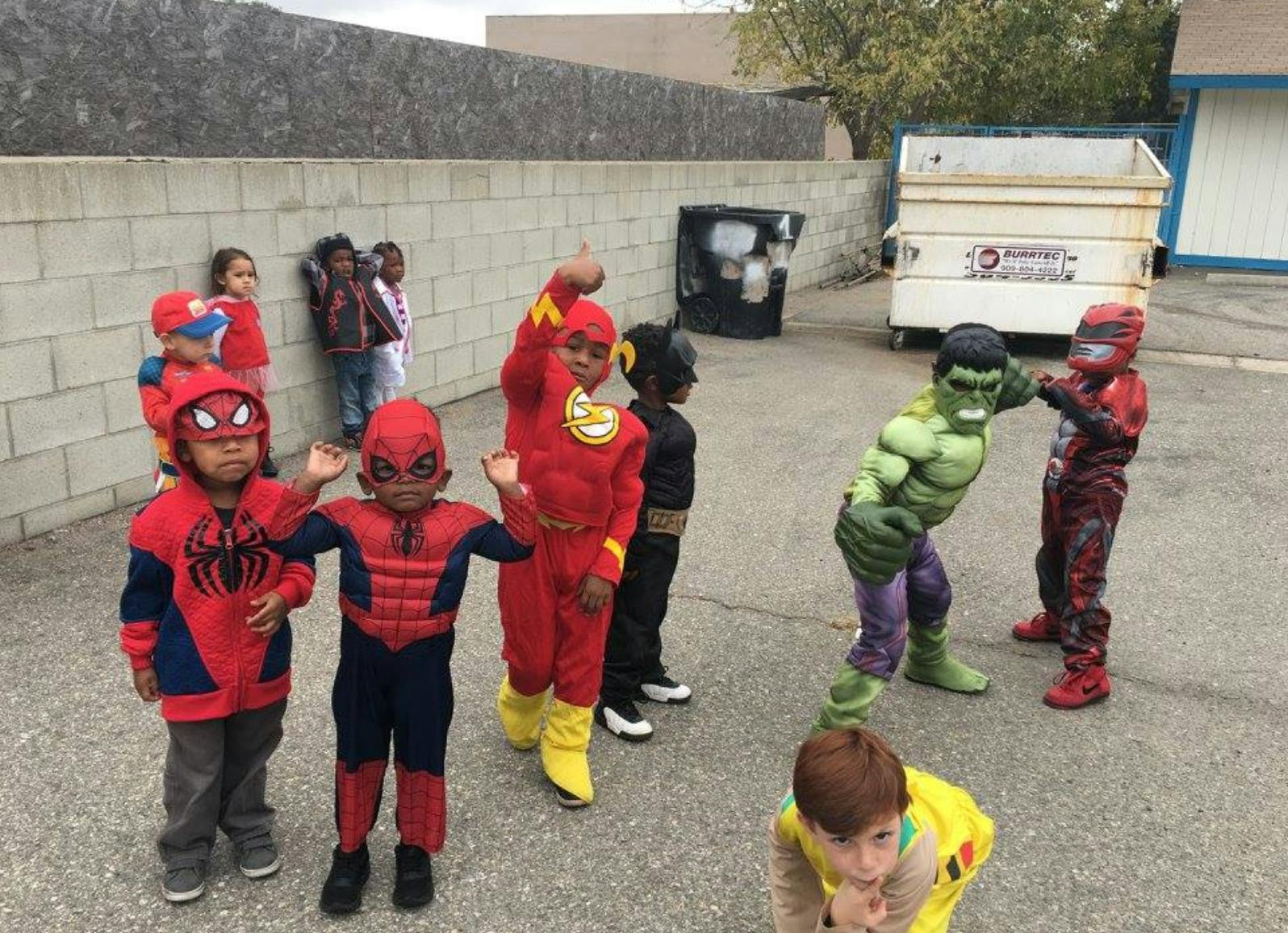 Children in superhero costumes playing outdoors