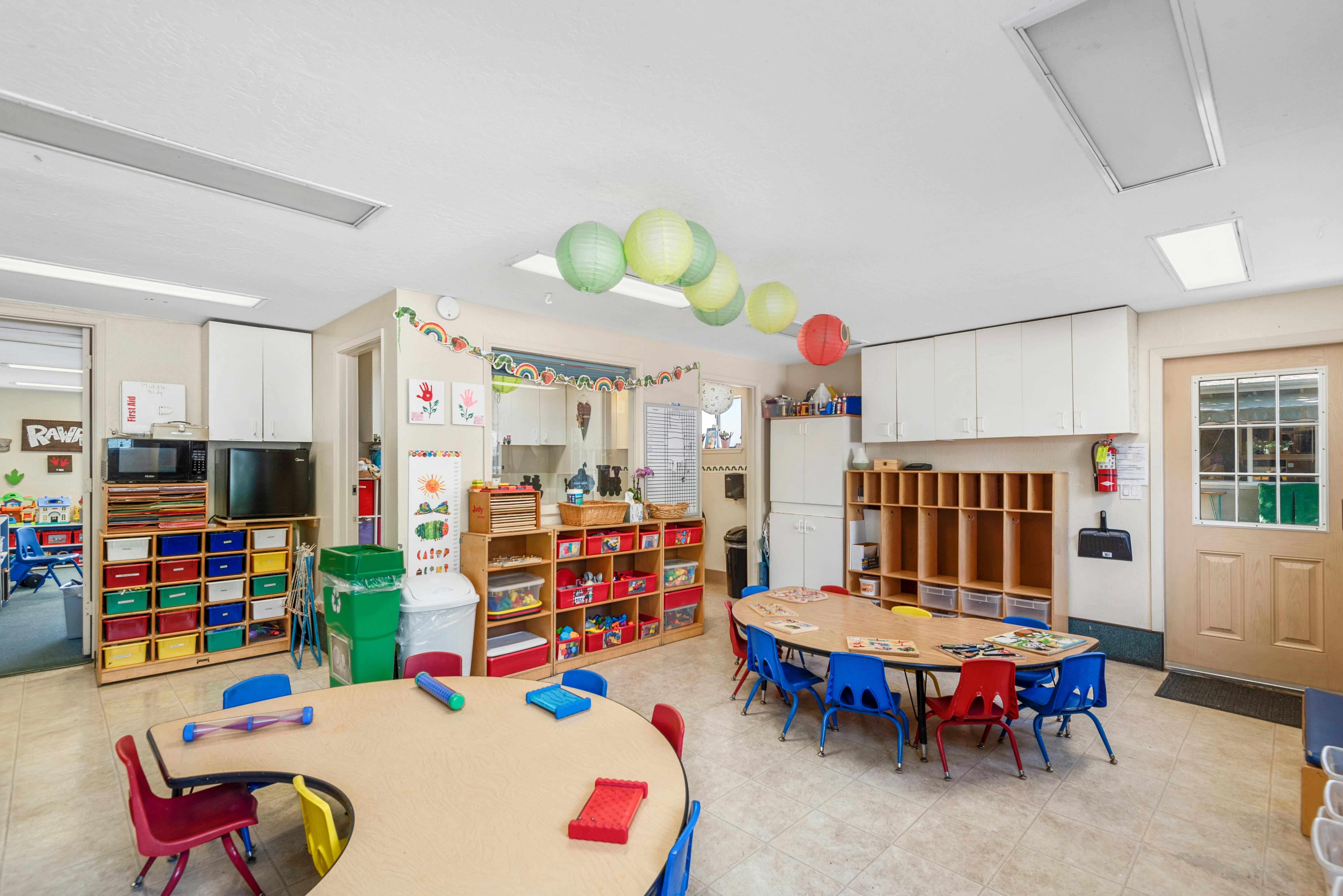 Classroom with tables, chairs, and storage units