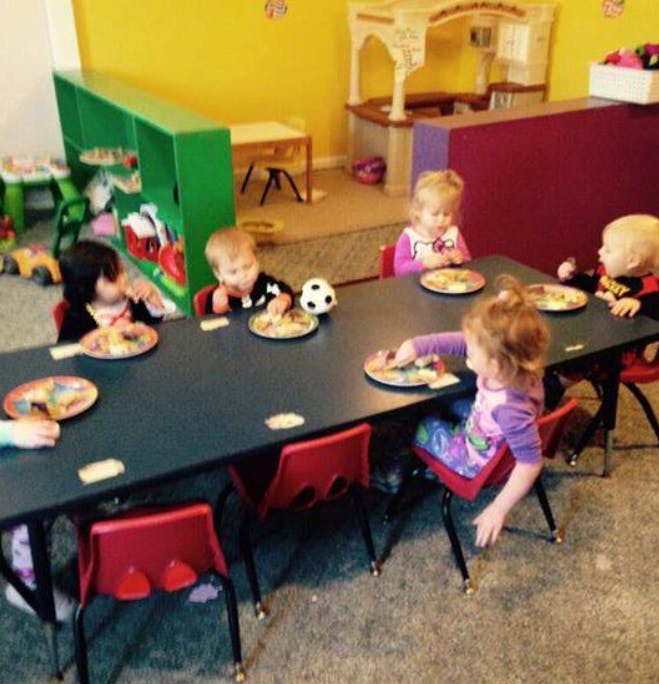 Children eating at a table in a classroom