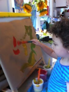Child painting on an easel