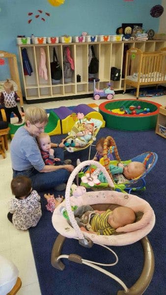 Adult with multiple babies and children in a room