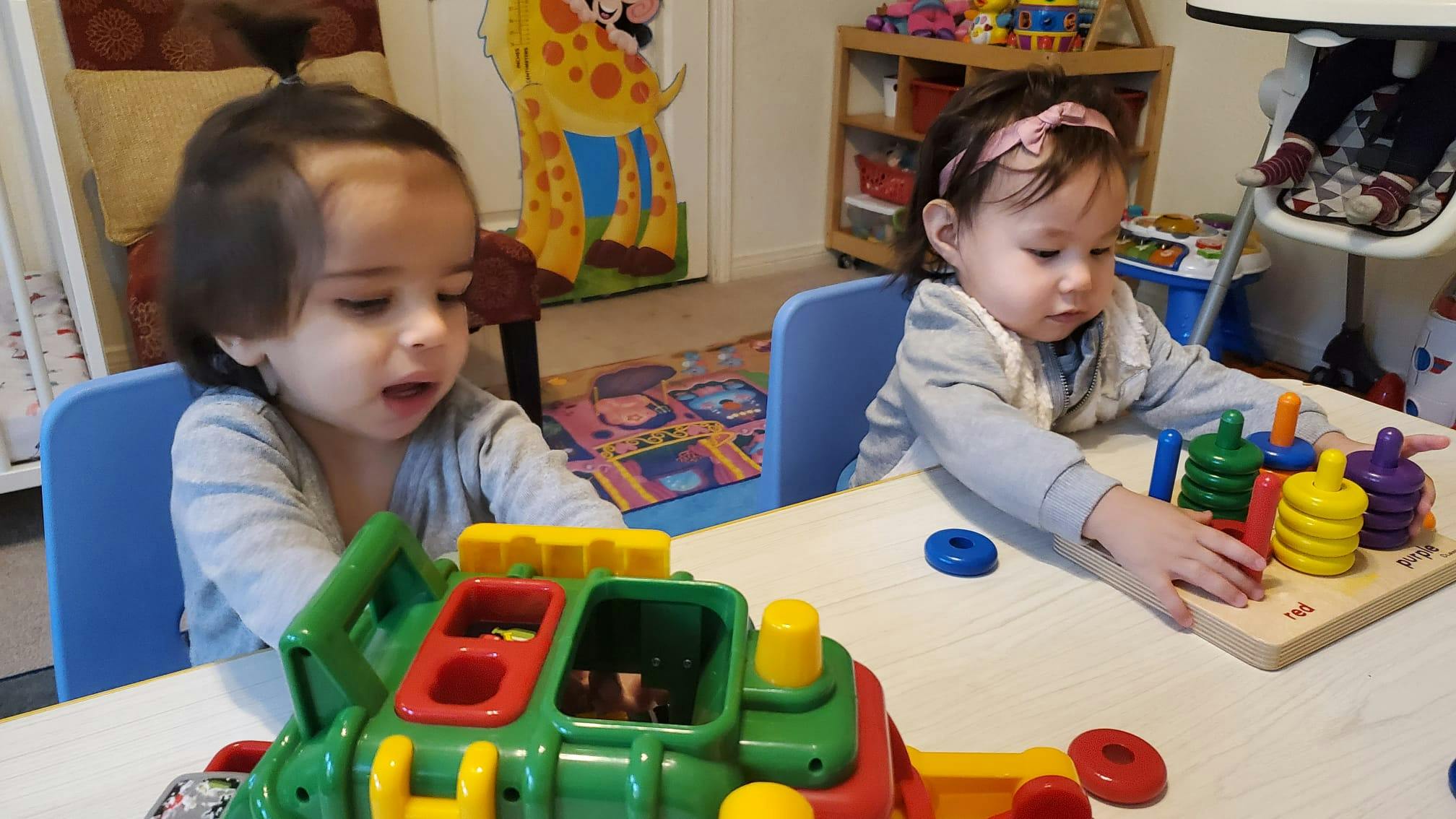 Two children playing with toys at a table