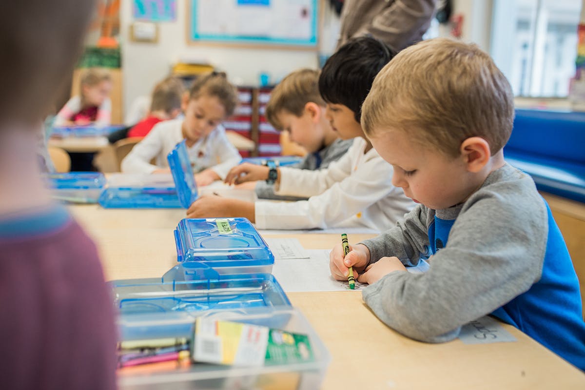 Children drawing at a table in a classroom