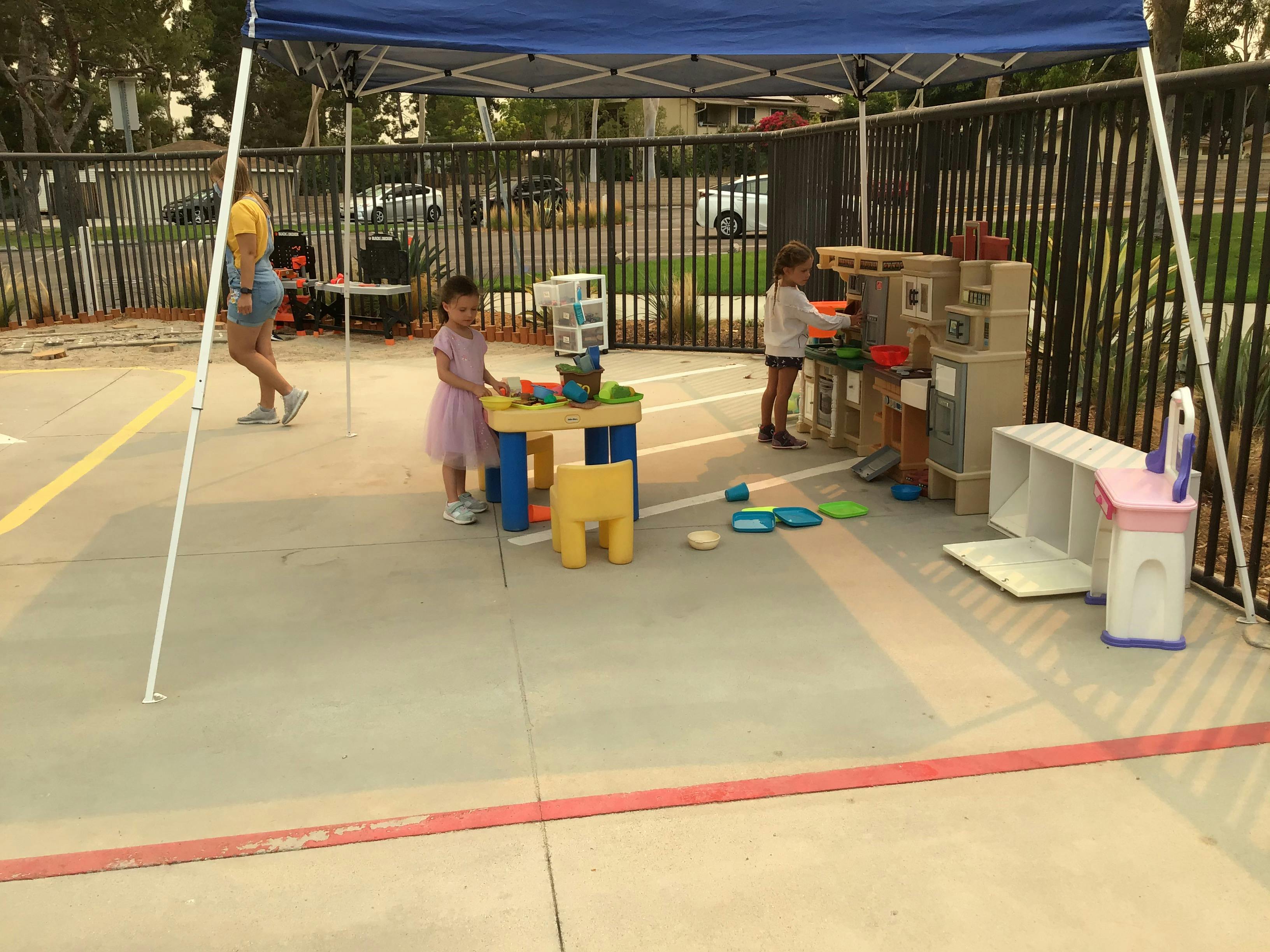 Children playing with toys under a canopy