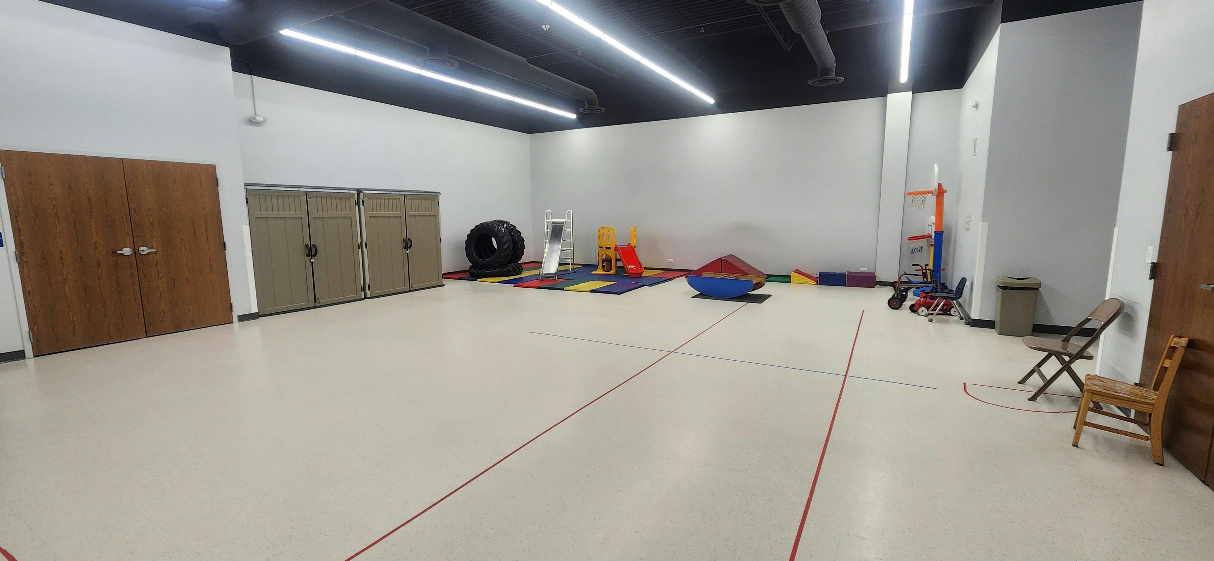 Empty room with play equipment and storage cabinets