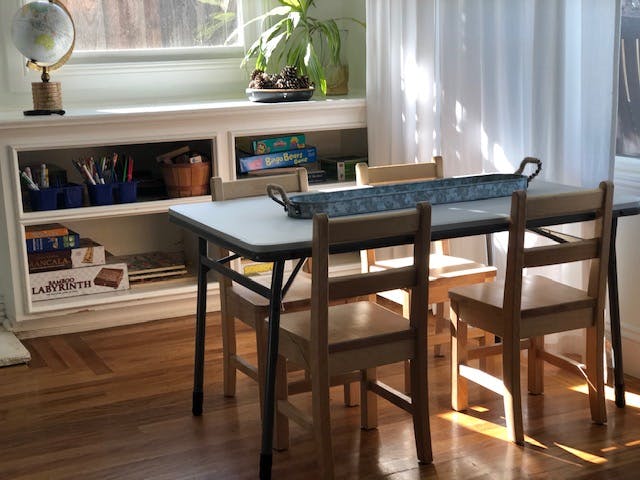 Table and chairs in a room with a bookshelf