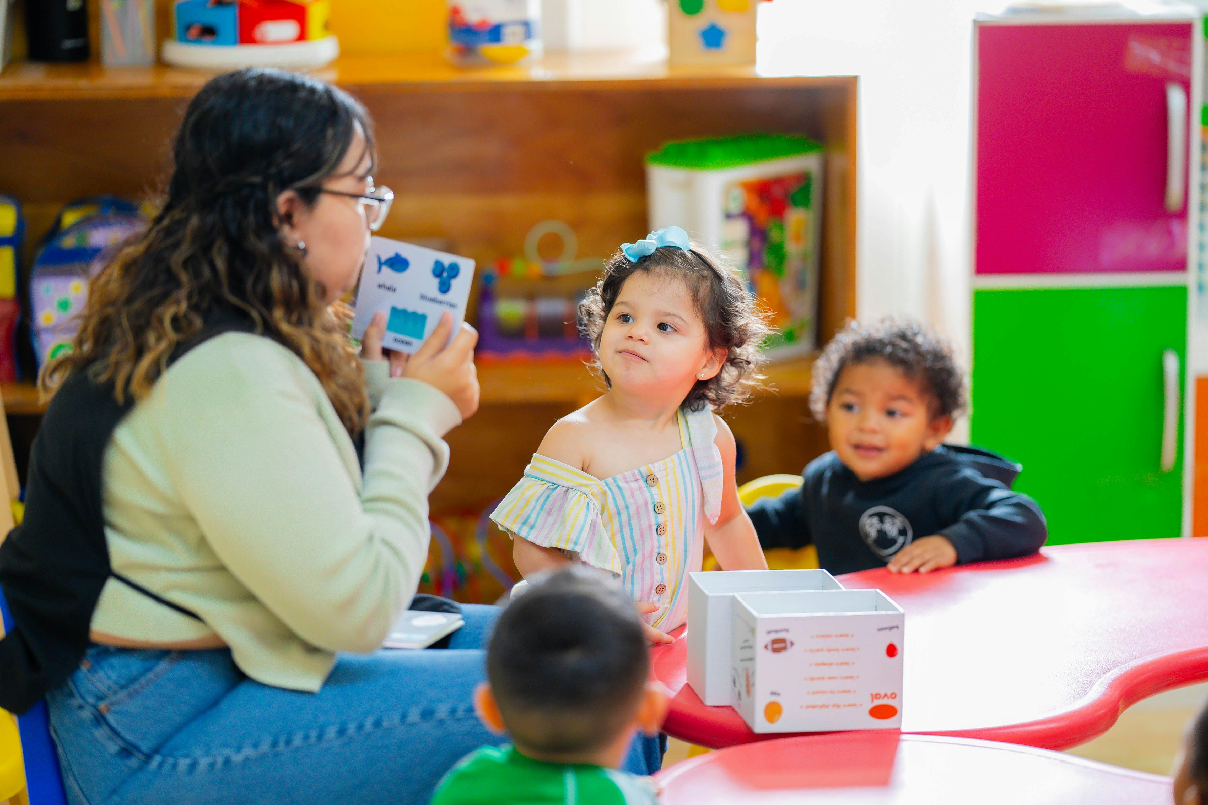 Person holding a card for children in a classroom