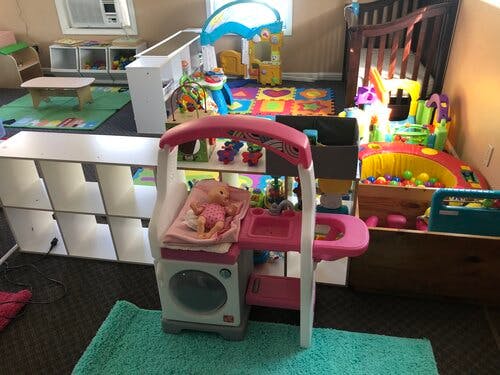Playroom with various toys, including a doll changing station and ball pit