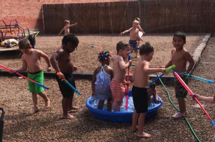 Children playing with water guns and a small pool outdoors