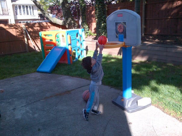 Child playing basketball outdoors