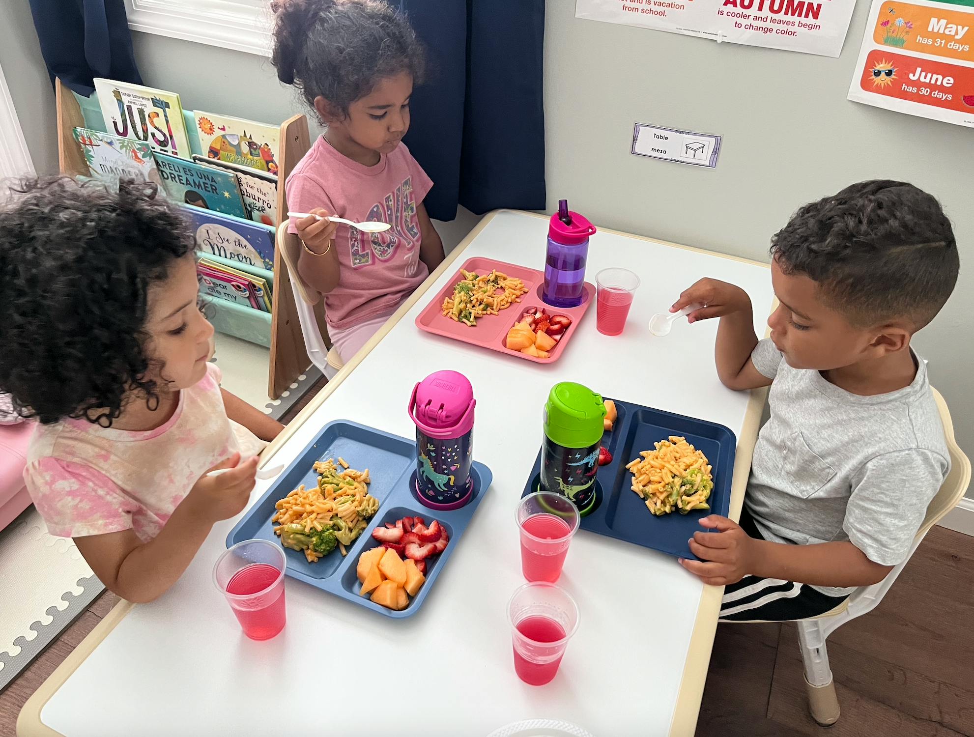 Three children eating meals at a table