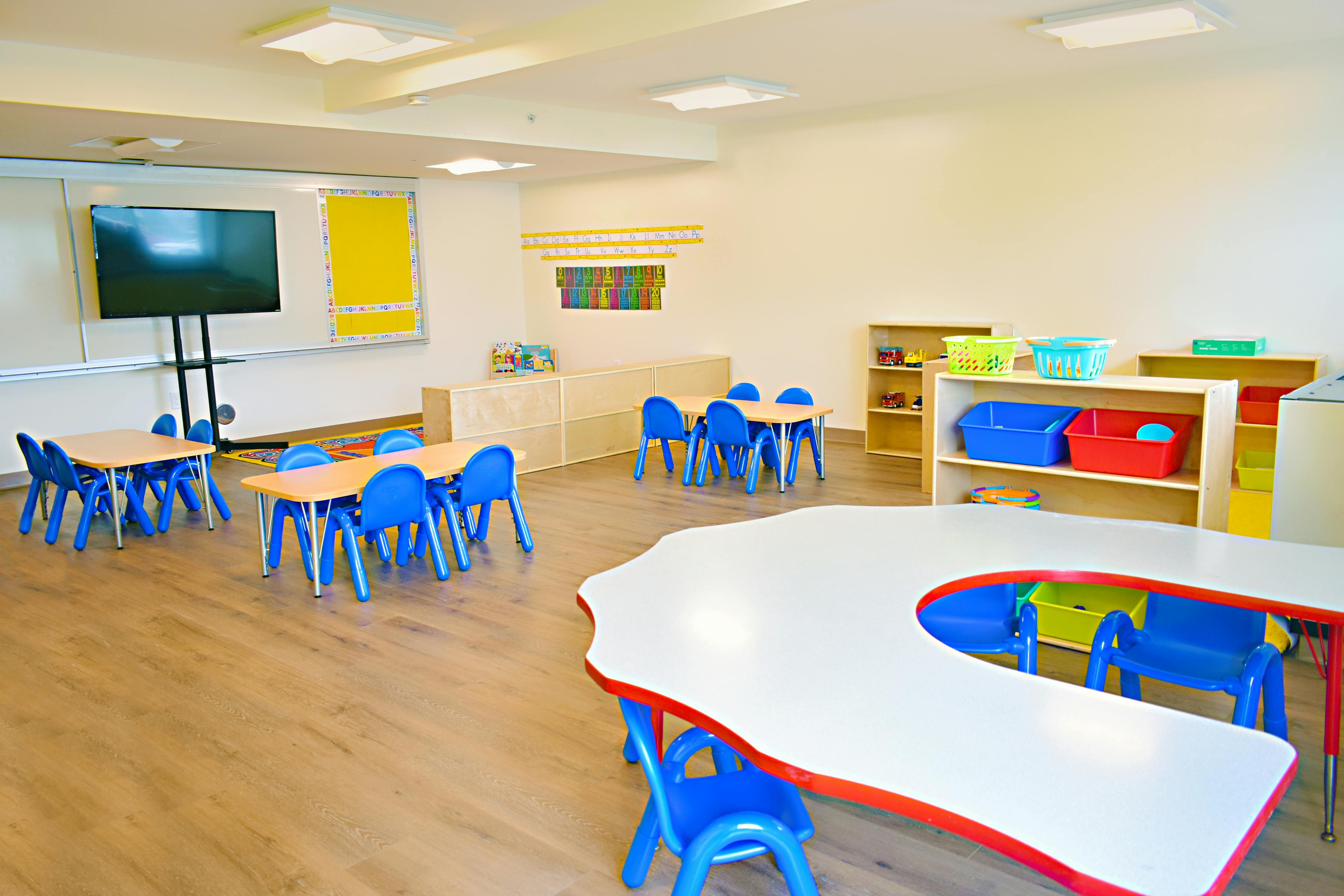 Empty classroom with small tables and blue chairs