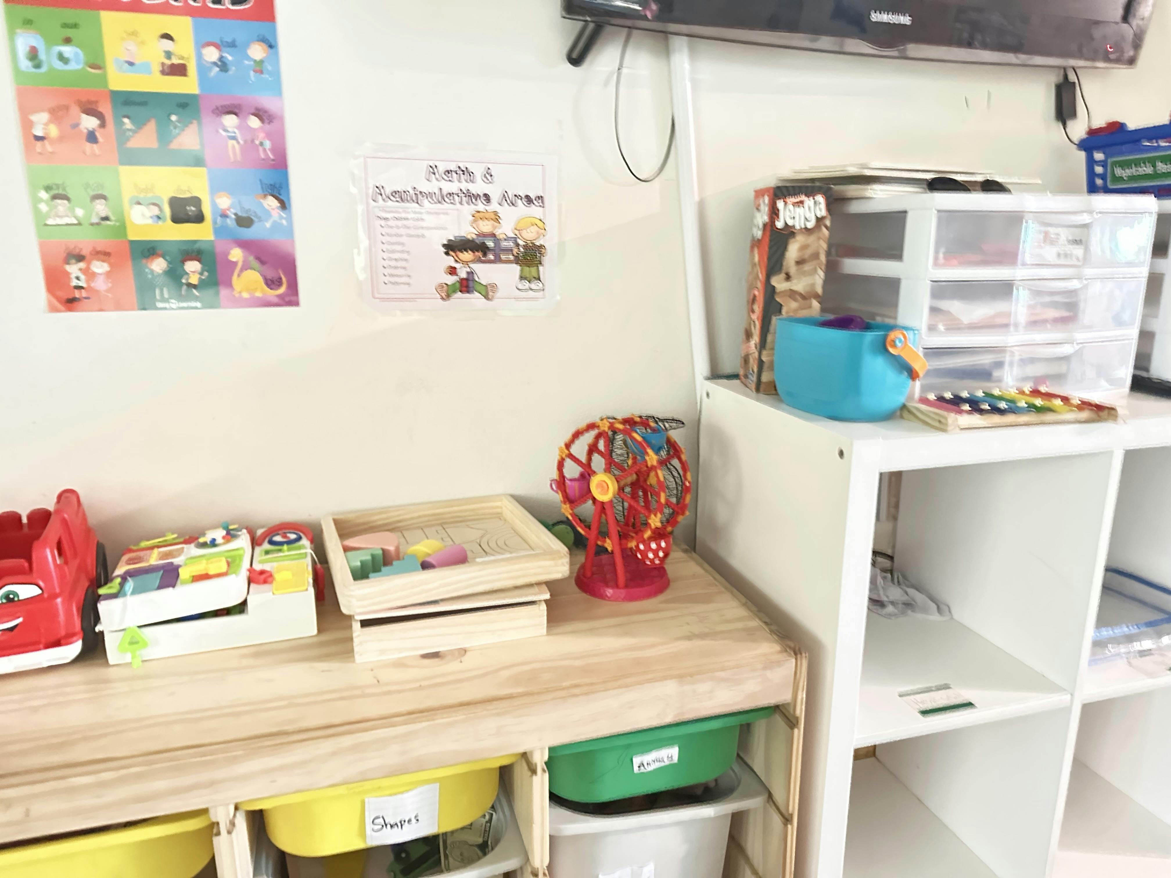 Classroom with toys on a wooden table and white shelves