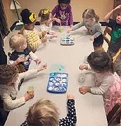 Children gathered around a table with toys
