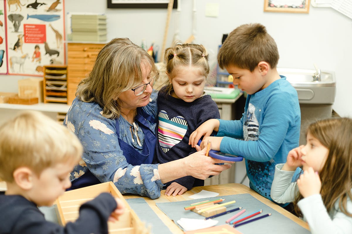 Adult and children at a table with art supplies