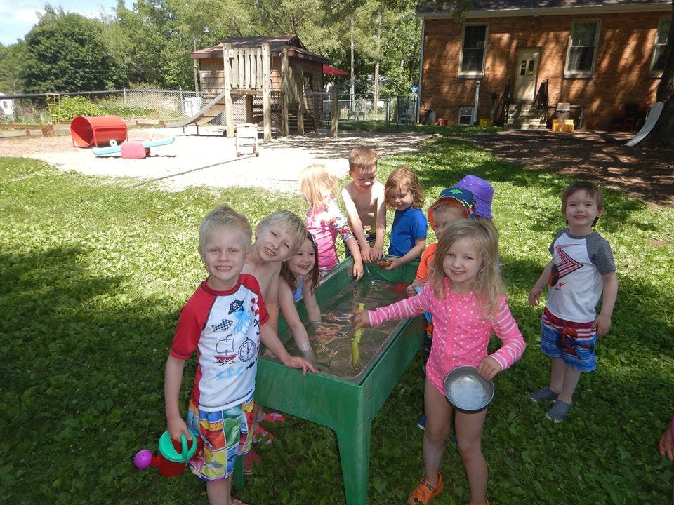 Children playing in a water table outdoors