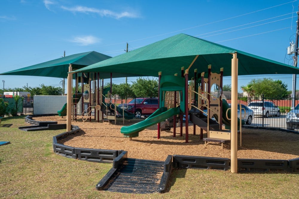 Playground with green slides and shade structures