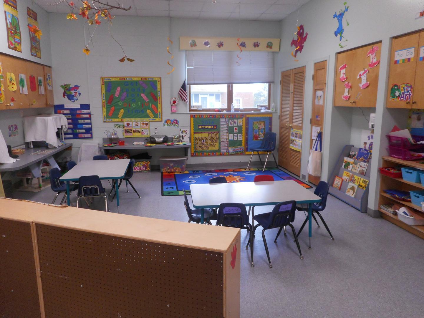 Empty classroom with small tables and chairs