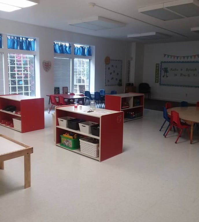 Classroom with red shelves, small tables, and chairs