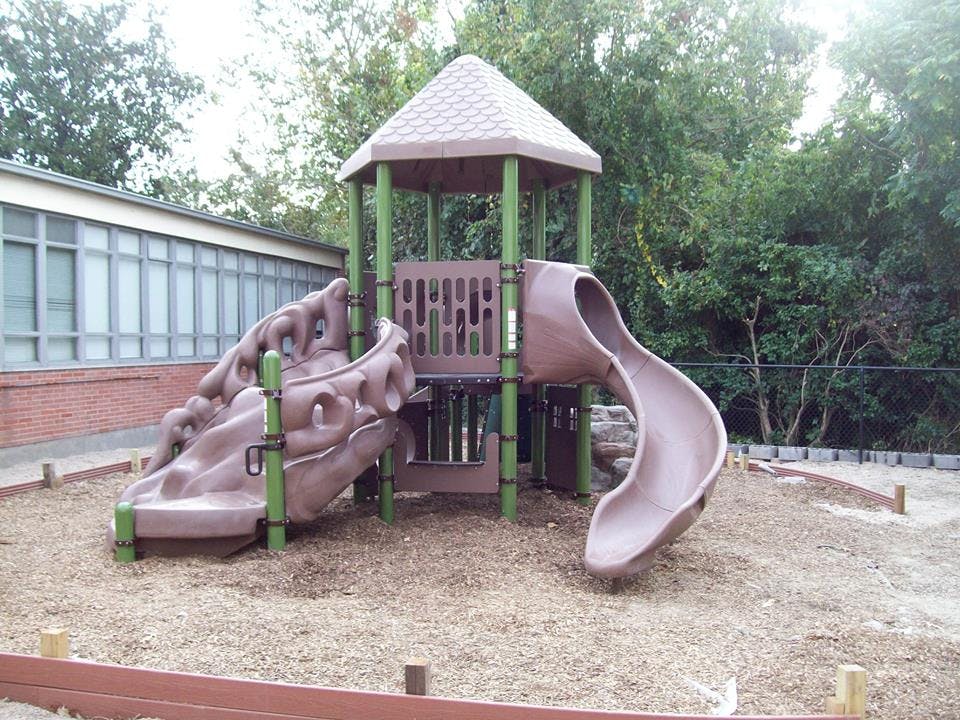Playground structure with slides and climbing wall