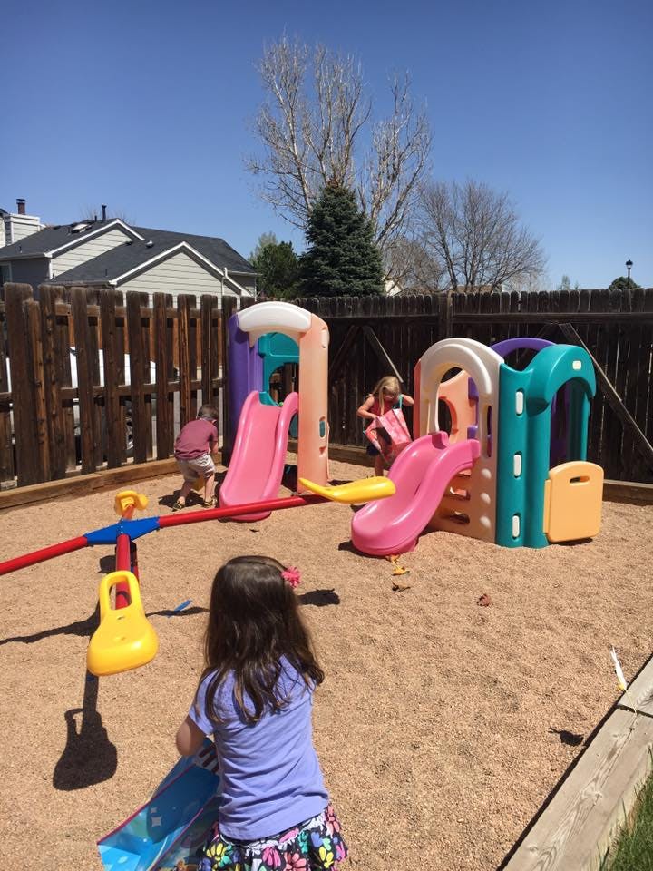 Children playing on a playground with slides and a seesaw