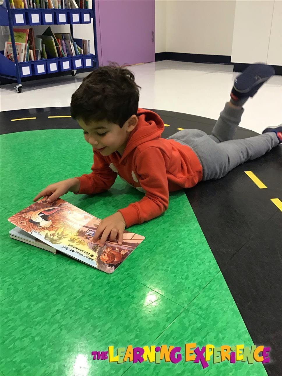 Child lying on floor reading a book