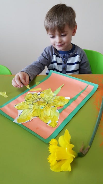 Child making a paper daffodil craft
