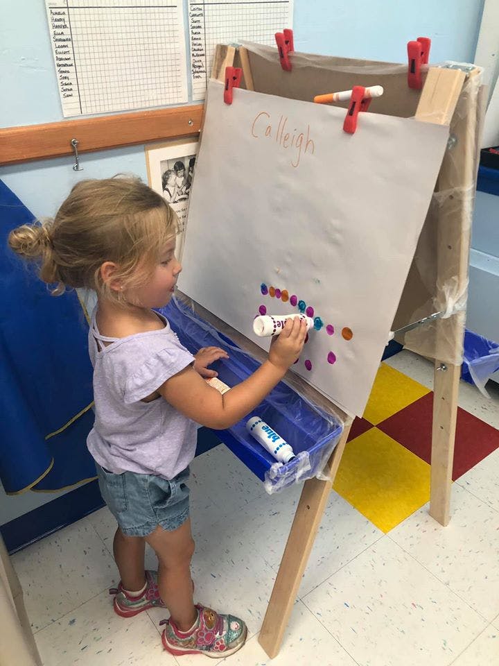 Child painting on an easel